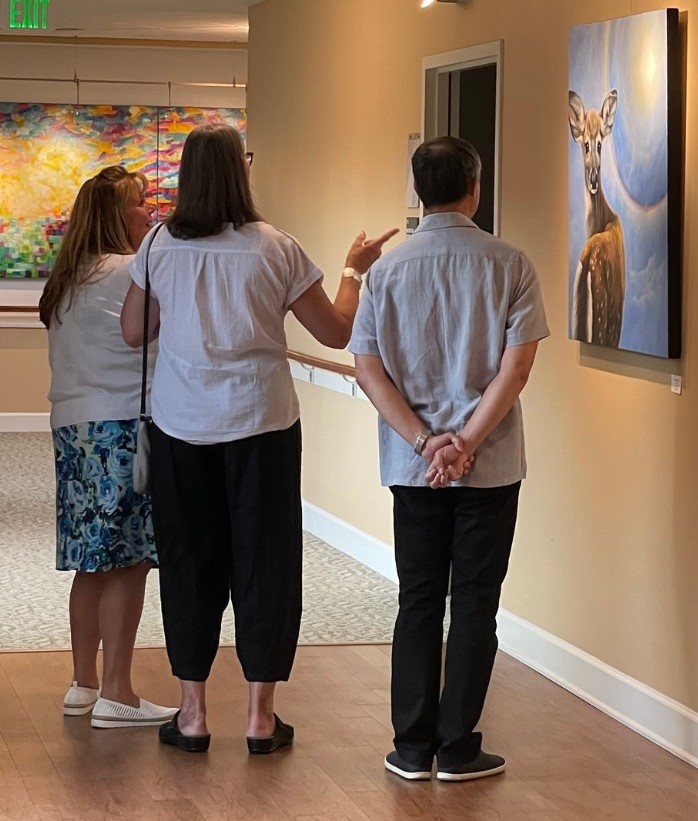 Art appreciaters in the Arts in Healing initiative by Perkins Center for the Arts at Samaritan Hospice Center standing in front of their work. 