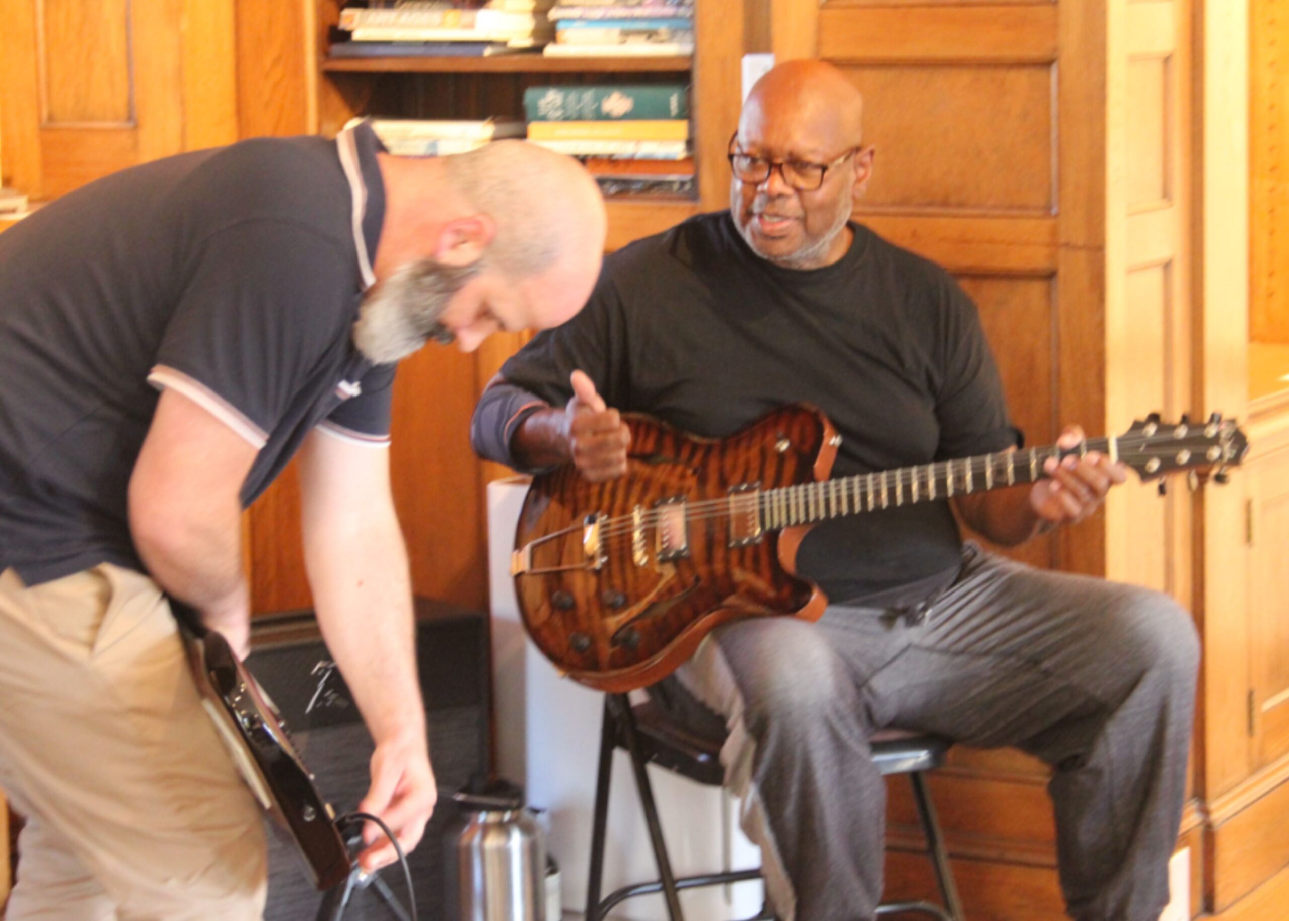 Volunteer helping a guitarist get set up