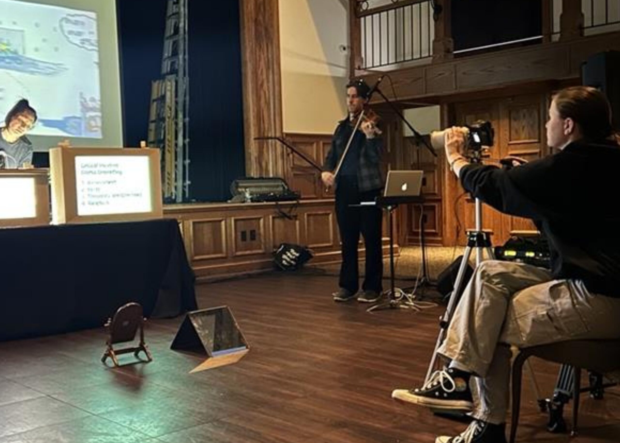 Volunteer filming a presentation on stage