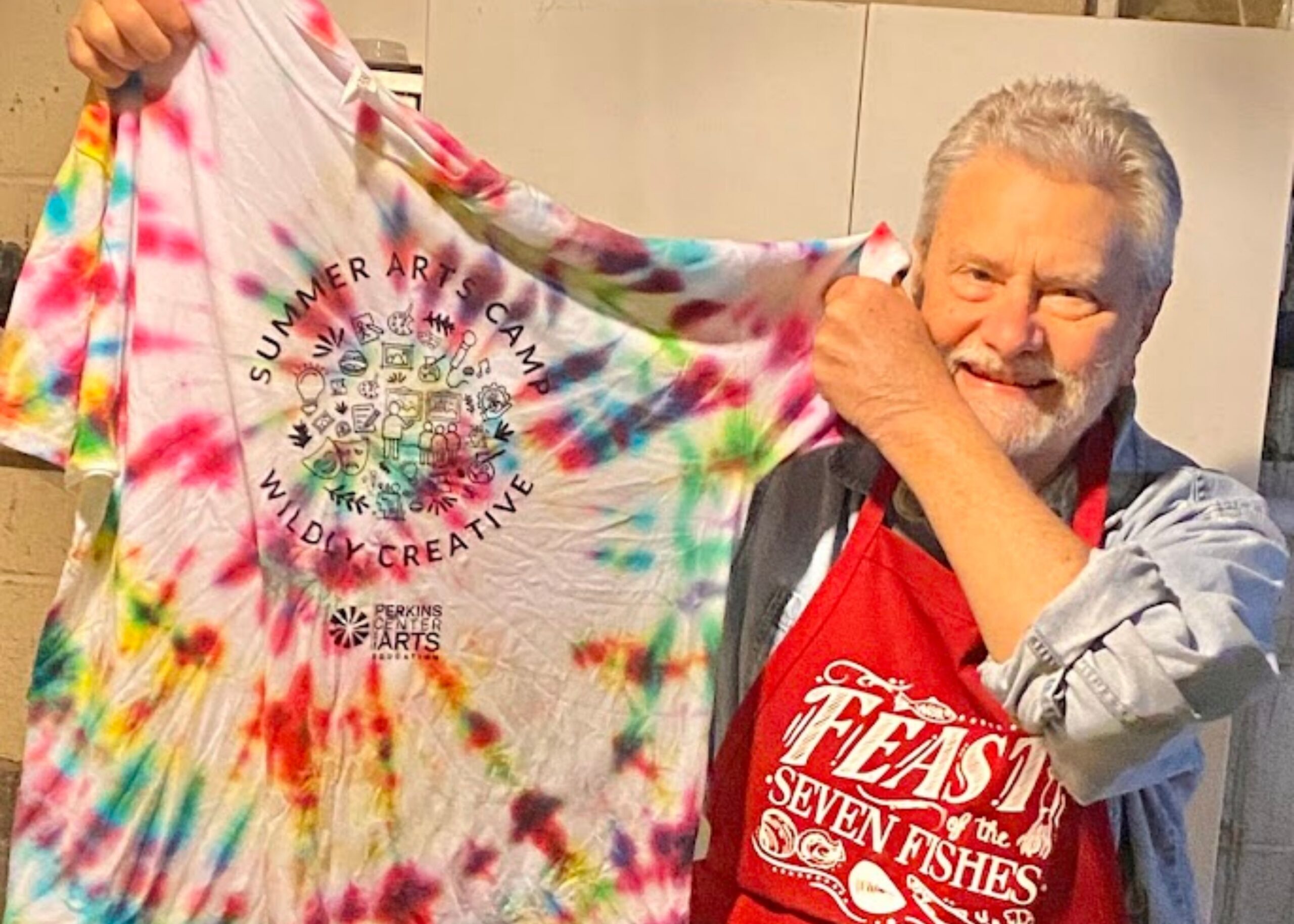 Volunteer holding up a tie-dyed shirt